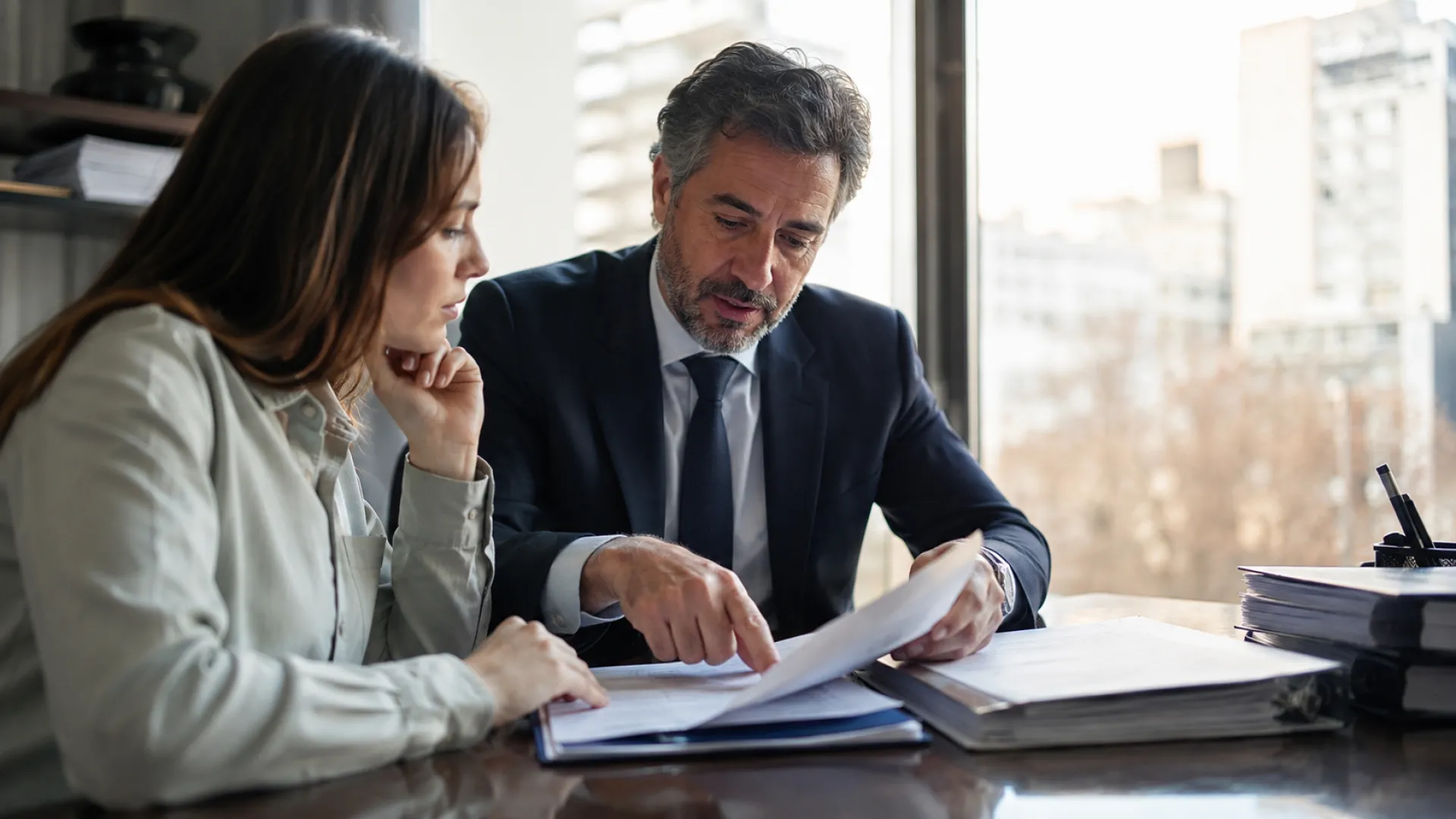 Abogado revisando escrituras y antecedentes registrales antes de autorizar la compra de una vivienda.